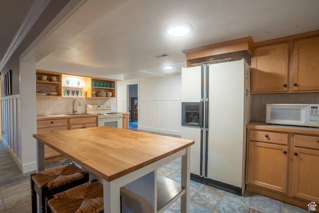 kitchen featuring visible vents, white appliances, wooden counters, a sink, and open shelves