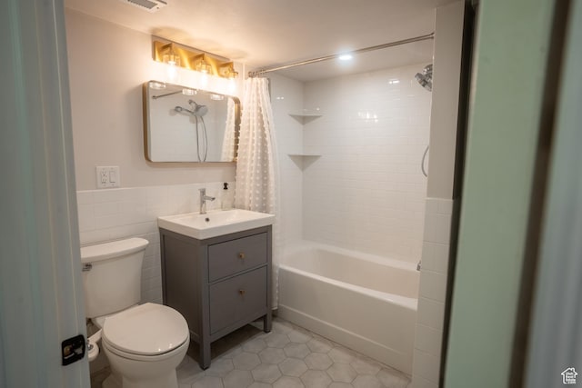 full bathroom featuring tile walls, toilet, vanity, shower / tub combo with curtain, and tile patterned flooring