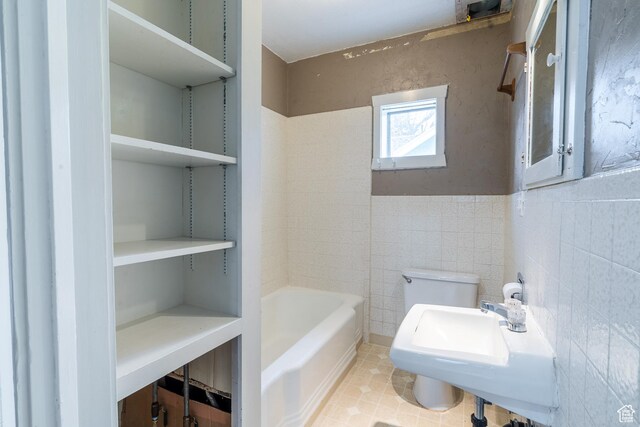 429 W Center St, Logan, UT 84321 - bathroom featuring tile patterned flooring, toilet, a sink, tile walls, and a bathtub