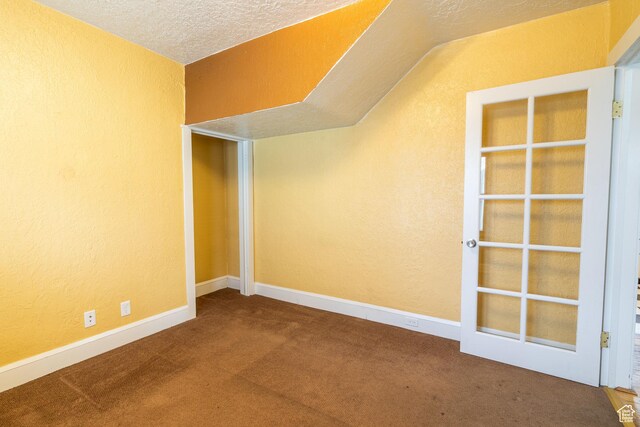 429 W Center St, Logan, UT 84321 - carpeted empty room with a textured ceiling, a textured wall, vaulted ceiling, and baseboards