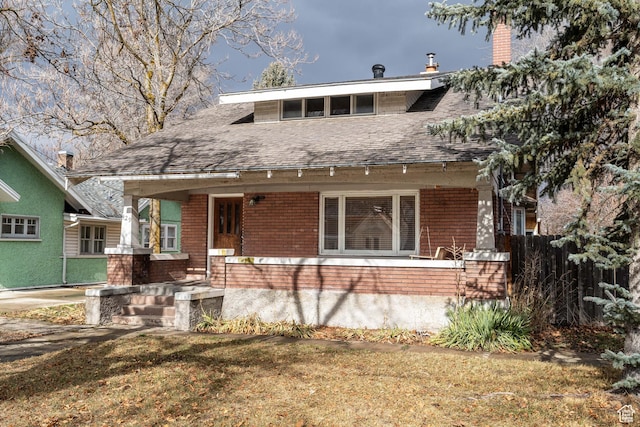 429 W Center St, Logan, UT 84321 - view of front of house with a shingled roof, a front lawn, a porch, and brick siding