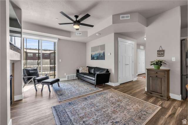 living room with baseboards, visible vents, and dark wood-type flooring