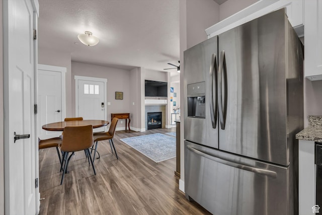 1051 S 500 E Unit E203, Heber City, UT 84032 - kitchen featuring ceiling fan, a glass covered fireplace, wood finished floors, baseboards, and stainless steel fridge