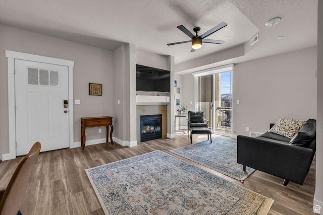 1051 S 500 E Unit E203, Heber City, UT 84032 - living room featuring a fireplace, a textured ceiling, baseboards, and wood finished floors