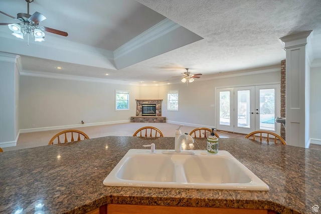 1986 Dove Dr, Santa Clara, UT 84765 - kitchen featuring a textured ceiling, a glass covered fireplace, a sink, and crown molding