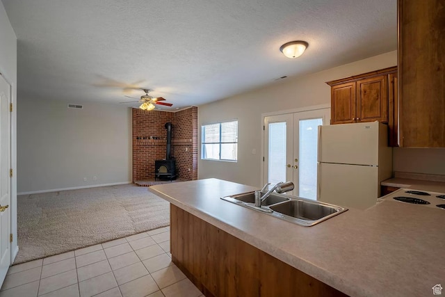 1986 Dove Dr, Santa Clara, UT 84765 - kitchen with light colored carpet, a sink, visible vents, freestanding refrigerator, and brown cabinets