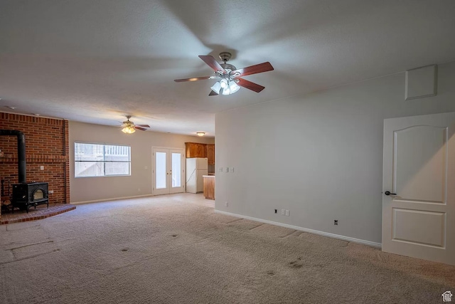 1986 Dove Dr, Santa Clara, UT 84765 - unfurnished living room featuring light colored carpet, a wood stove, ceiling fan, a textured ceiling, and baseboards