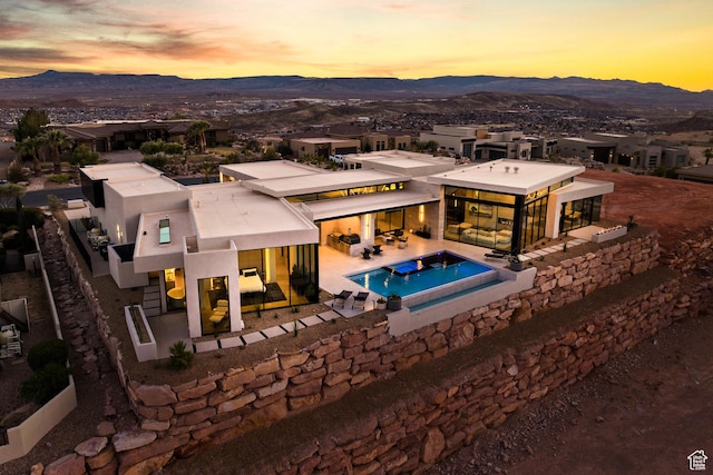 2031 E Pinnacle Dr, St George, UT 84790 - pool at dusk featuring a patio, a hot tub, a mountain view, and an outdoor pool