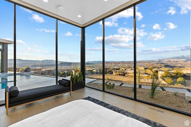 2031 E Pinnacle Dr, St George, UT 84790 - unfurnished bedroom featuring visible vents, wood finished floors, a mountain view, and floor to ceiling windows