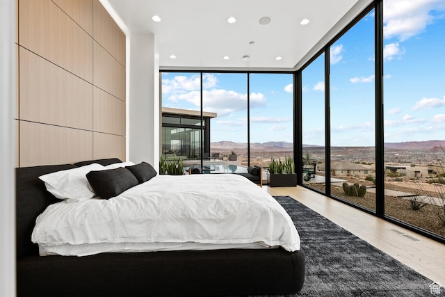 2031 E Pinnacle Dr, St George, UT 84790 - bedroom with expansive windows, a mountain view, wood finished floors, and recessed lighting