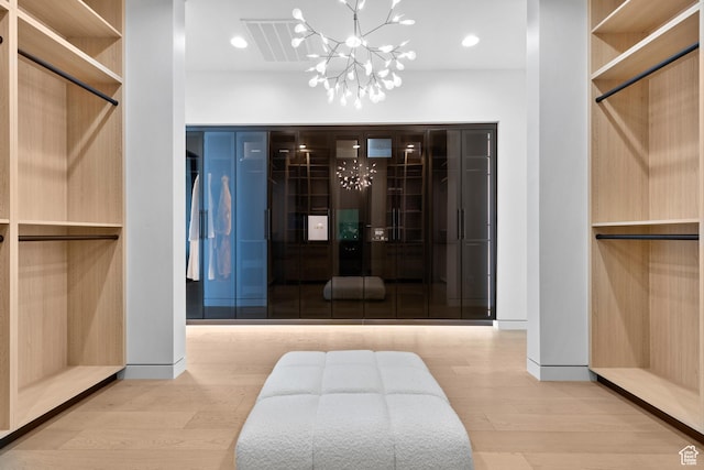 2031 E Pinnacle Dr, St George, UT 84790 - walk in closet featuring visible vents, an inviting chandelier, and wood finished floors