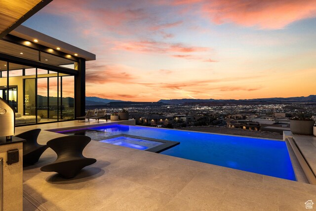 2031 E Pinnacle Dr, St George, UT 84790 - pool at dusk with a patio area, a pool with connected hot tub, and a mountain view
