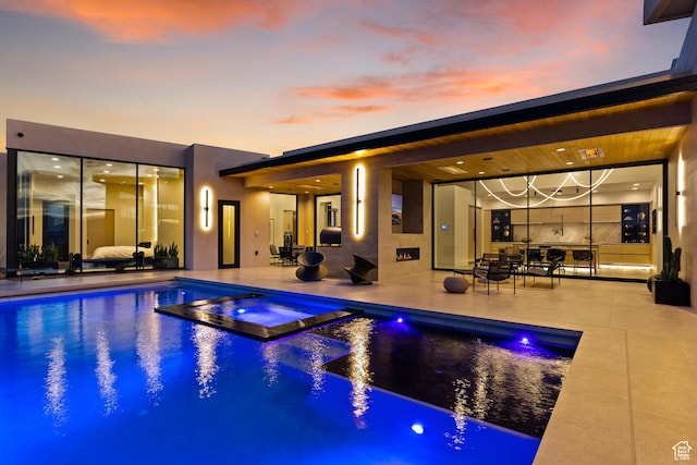 2031 E Pinnacle Dr, St George, UT 84790 - pool at dusk featuring a pool with connected hot tub and a patio