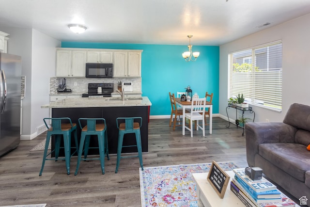 2451 S Gilmour St, West Haven, UT 84401 - kitchen with visible vents, decorative backsplash, wood finished floors, black appliances, and a sink