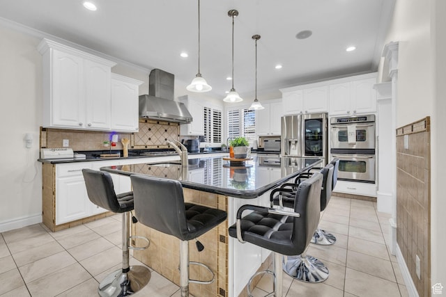 6067 S 3950 W, Roy, UT 84067 - kitchen featuring light tile patterned floors, a kitchen island with sink, wall chimney range hood, appliances with stainless steel finishes, and dark countertops