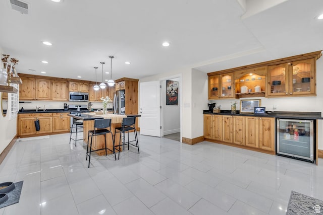 6067 S 3950 W, Roy, UT 84067 - kitchen with wine cooler, a breakfast bar area, dark countertops, visible vents, and appliances with stainless steel finishes