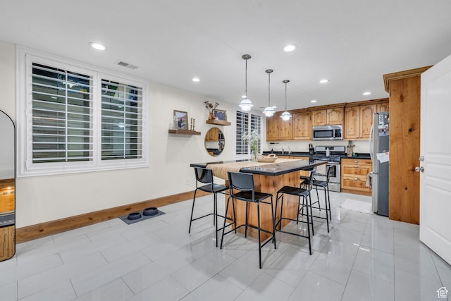 6067 S 3950 W, Roy, UT 84067 - kitchen featuring visible vents, a kitchen island, a breakfast bar area, stainless steel appliances, and recessed lighting