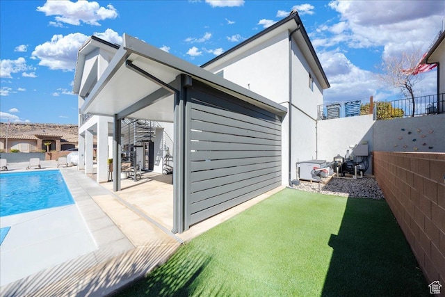 back of property with a patio area, a fenced backyard, and a fenced in pool