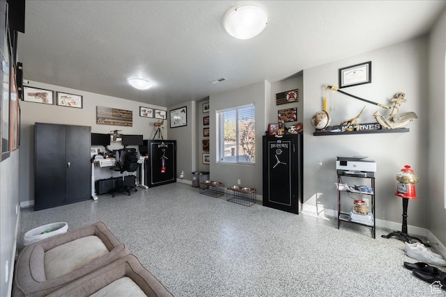 office featuring visible vents, baseboards, a textured ceiling, and speckled floor