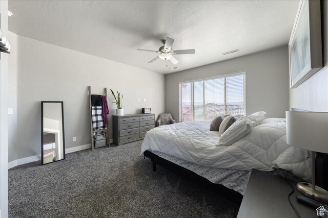 bedroom with baseboards, visible vents, a ceiling fan, a textured ceiling, and carpet flooring