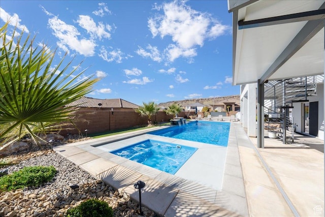 view of pool featuring a fenced backyard, a fenced in pool, a patio, and an in ground hot tub