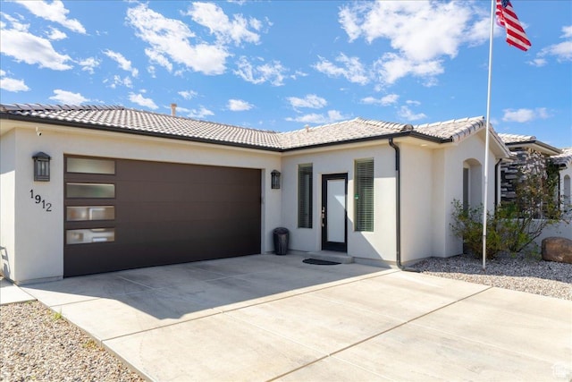 view of front of property with driveway, stucco siding, a garage, and a tiled roof