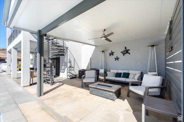 view of patio with stairway, an outdoor living space with a fire pit, and a ceiling fan
