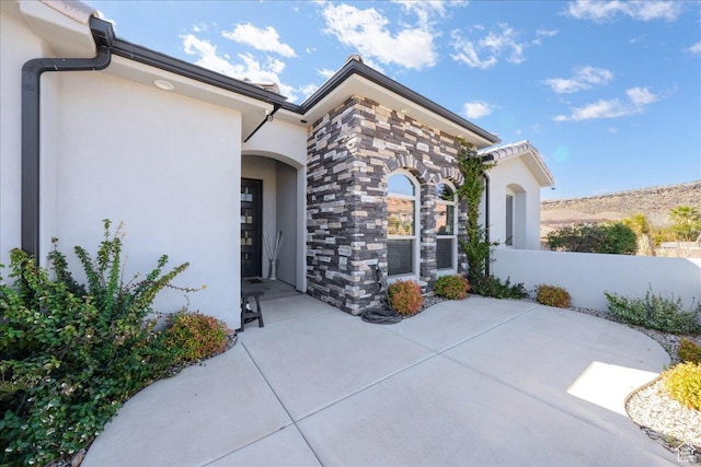 property entrance with stone siding and stucco siding