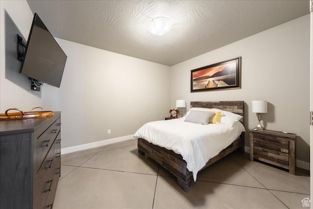 bedroom with a textured ceiling, concrete floors, and baseboards
