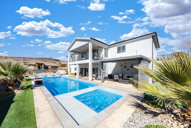 rear view of house featuring a fenced in pool, a patio, a balcony, ceiling fan, and an outdoor hangout area