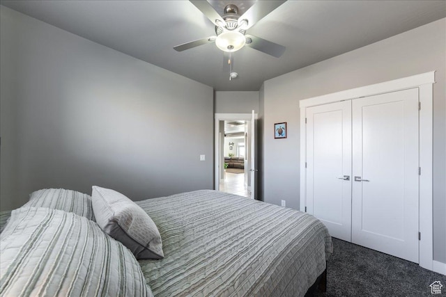 bedroom featuring ceiling fan, dark colored carpet, and a closet