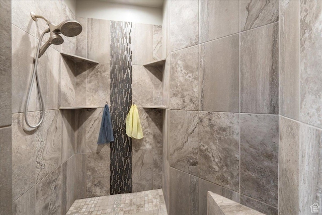 interior details featuring tiled shower