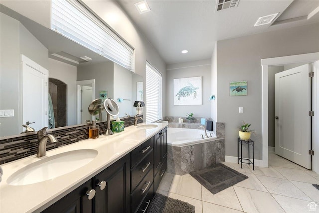 bathroom featuring a garden tub, visible vents, and a sink