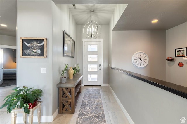 foyer featuring baseboards, stairway, and a notable chandelier