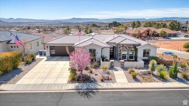 view of front of property featuring a tiled roof, concrete driveway, fence, and a mountain view