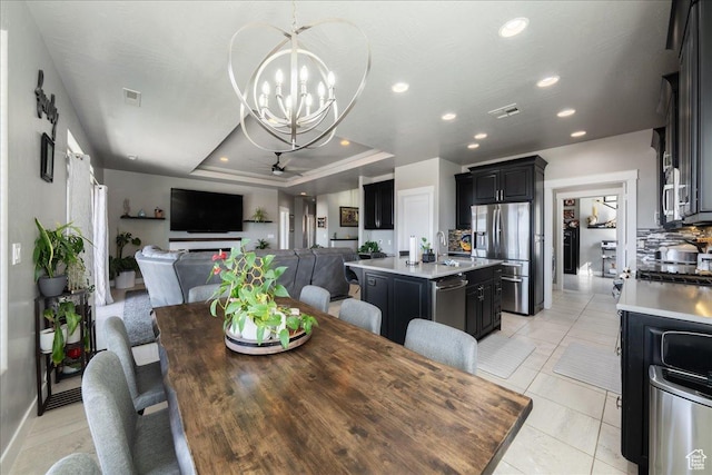 dining area featuring recessed lighting, visible vents, ceiling fan with notable chandelier, a tray ceiling, and light tile patterned flooring