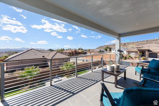 view of patio featuring a residential view, a mountain view, and a balcony