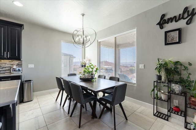 dining space with an inviting chandelier, light tile patterned floors, and baseboards