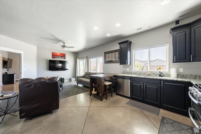 kitchen with stainless steel appliances, finished concrete floors, open floor plan, a sink, and light stone countertops