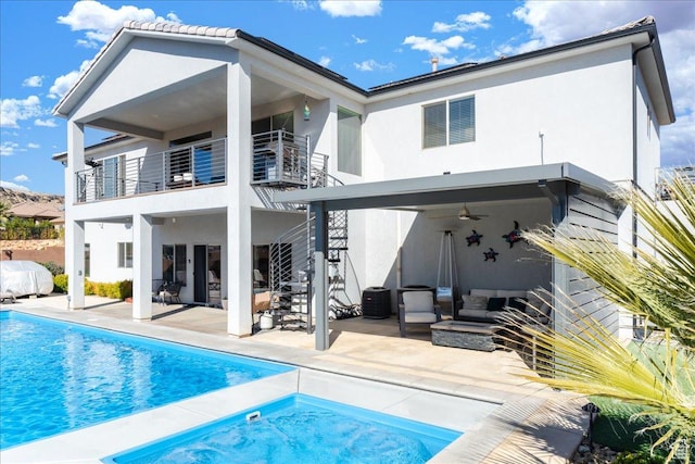 back of property with stucco siding, an outdoor living space, and a patio