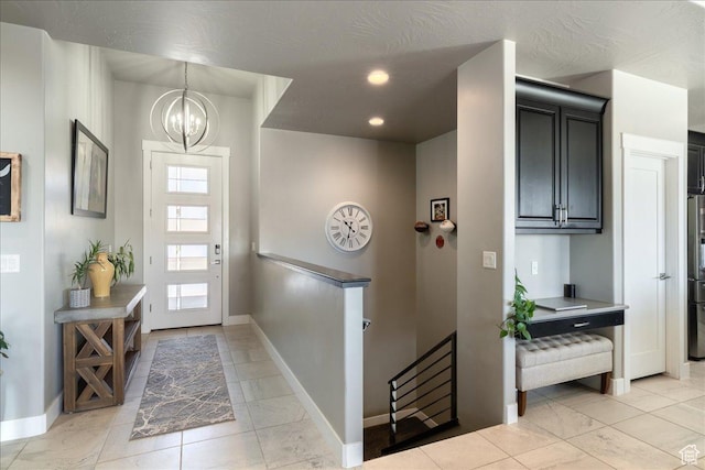 foyer entrance with a chandelier, recessed lighting, and baseboards