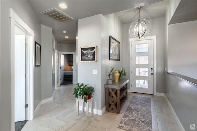 entrance foyer featuring a chandelier, visible vents, baseboards, and light tile patterned floors