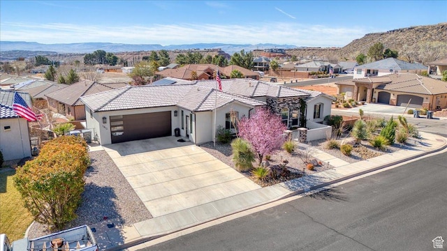 view of front of house featuring a mountain view, driveway, a residential view, and a garage