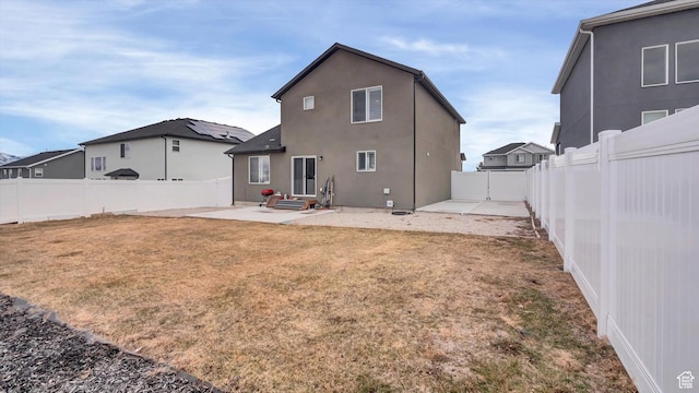 rear view of property featuring entry steps, a lawn, a patio, a fenced backyard, and stucco siding
