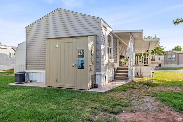 1160 E Telegraph St Unit 220, Washington, UT 84780 - view of side of property featuring a lawn, an outbuilding, a shed, and central AC unit