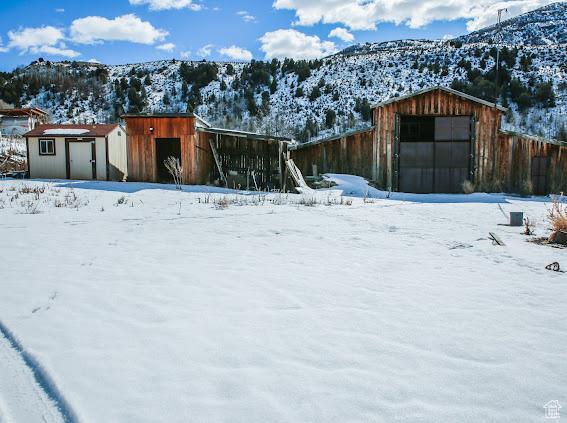 1290 Echo Crk Unit 2, Echo, UT 84024 - yard layered in snow with a detached garage, a mountain view, and an outbuilding