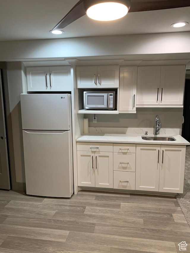 3606 E 375 S, Roosevelt, UT 84066 - kitchen featuring light wood-type flooring, stainless steel microwave, a sink, and freestanding refrigerator