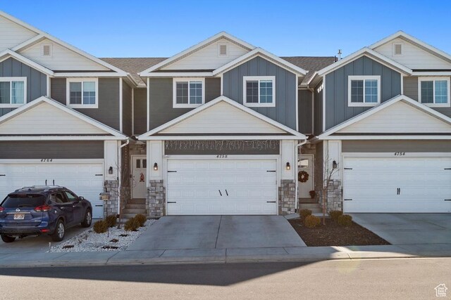 view of front of home with driveway, a shingled roof, a garage, and board and batten siding