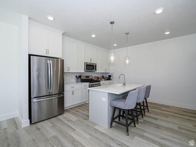 3361 W 3275 N, Plain City, UT 84404 - kitchen featuring appliances with stainless steel finishes, a kitchen breakfast bar, a sink, white cabinetry, and backsplash