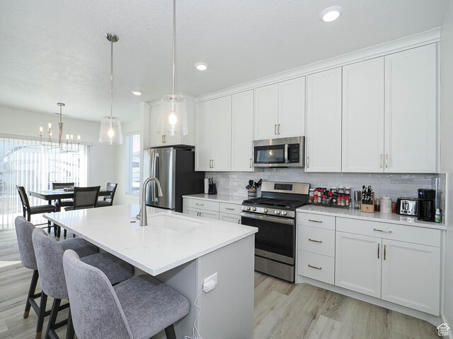 3361 W 3275 N, Plain City, UT 84404 - kitchen featuring appliances with stainless steel finishes, white cabinets, a sink, and tasteful backsplash